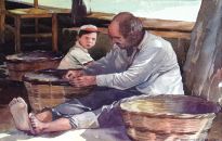 A fisherman mending baskets watched by his young protegè 
on the island of Skiathos in Greece.